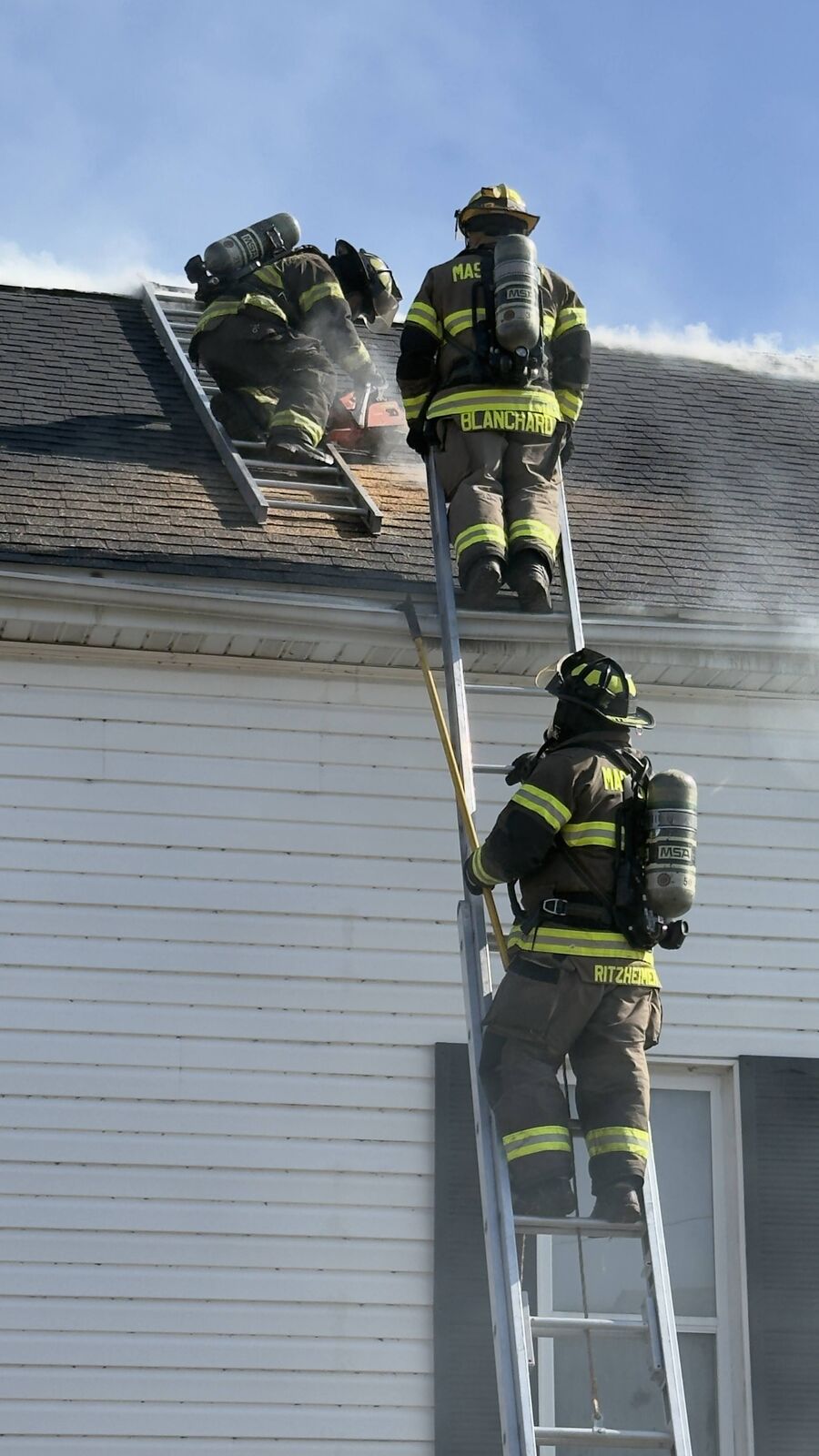 Mascoutah firefighters performing vertical ventilation on a roof